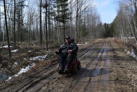 Yannick Côté travaille sur sa terre en quadriporteur